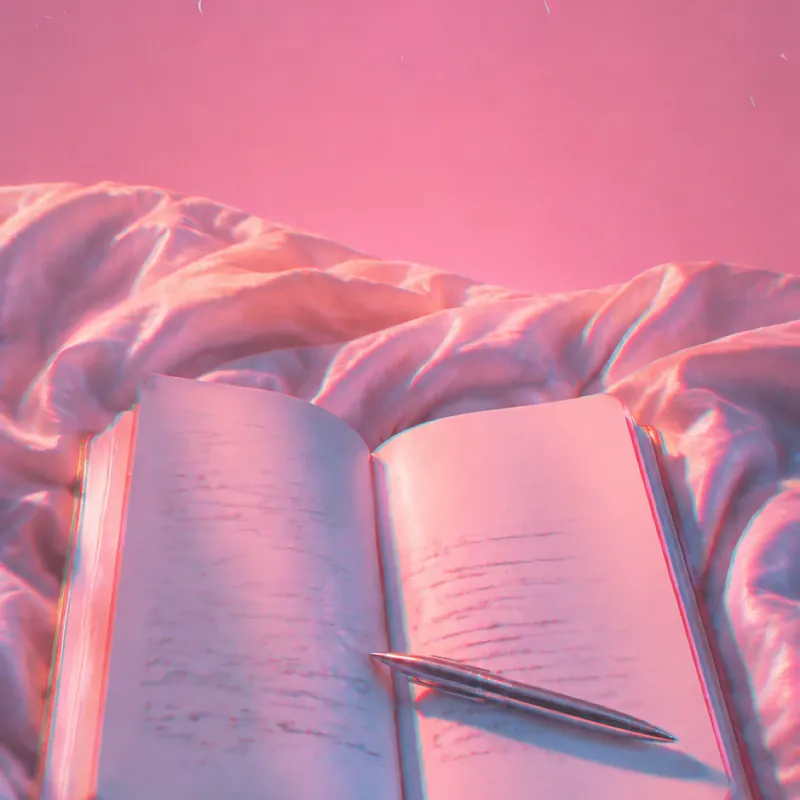 Dreamscape b-roll frame of a notebook on bed sheets